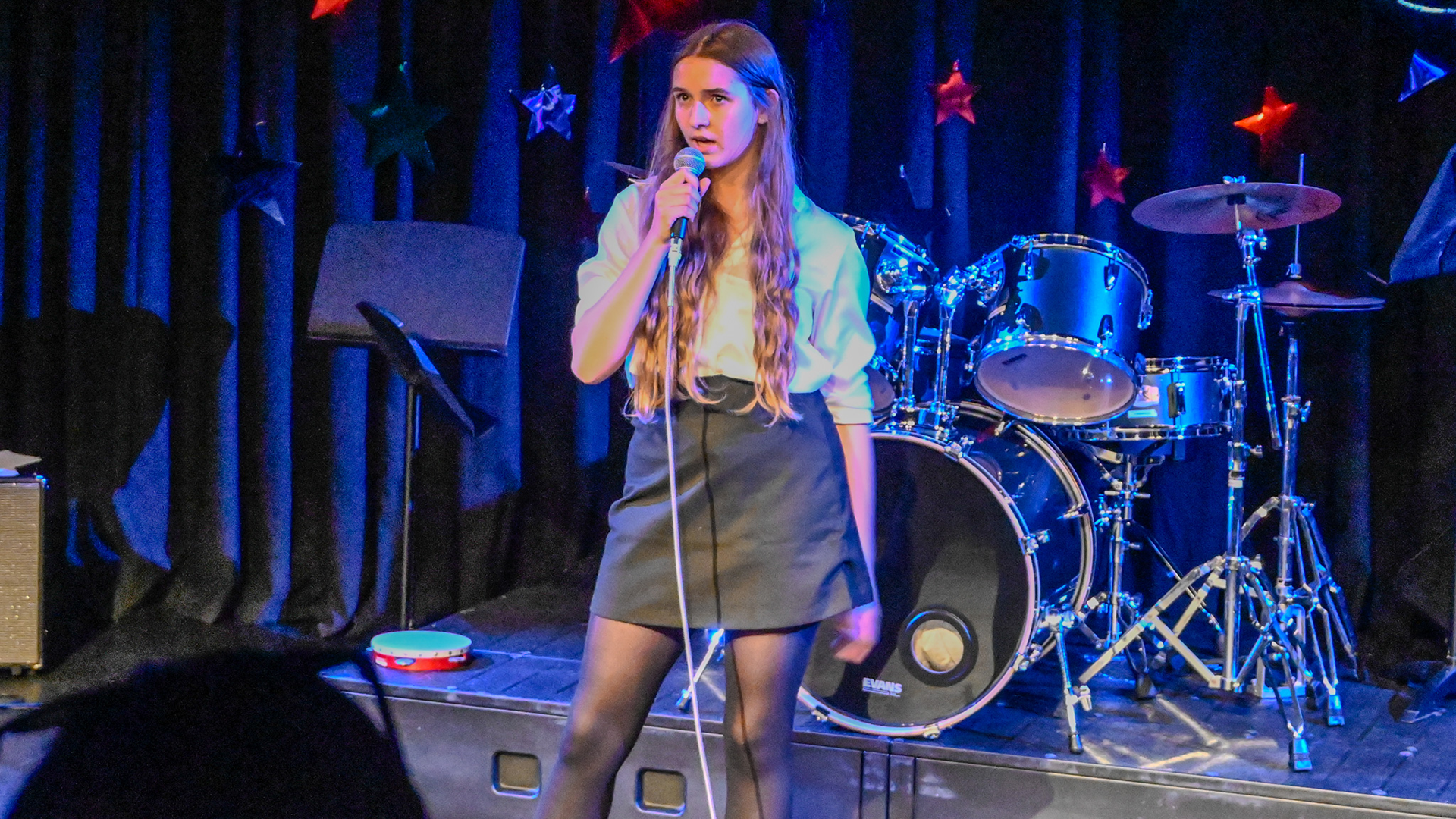 Senior school girl giving a solo performance on stage at the Freemen's LIVE show